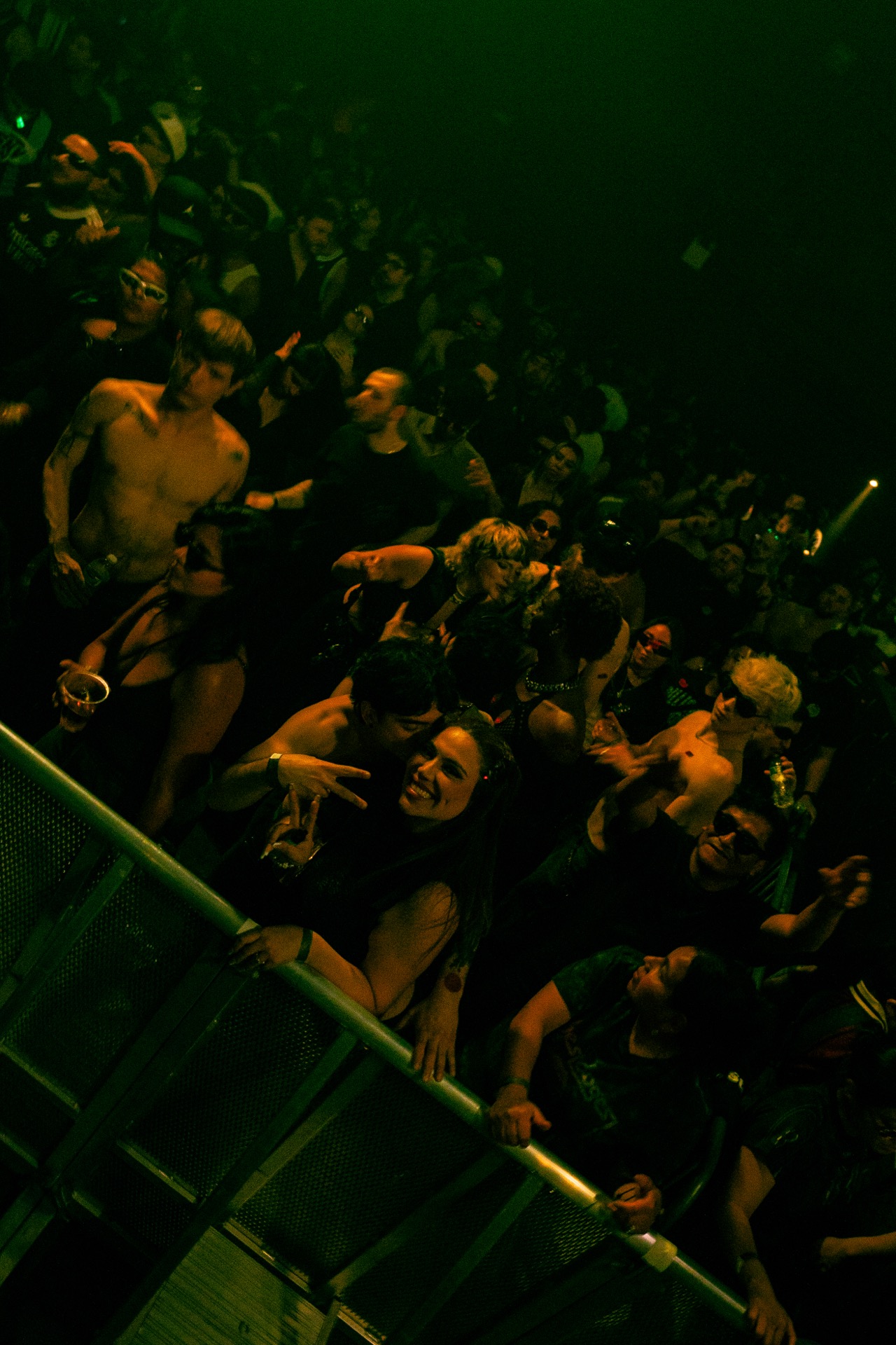 Crowd dancing under green light